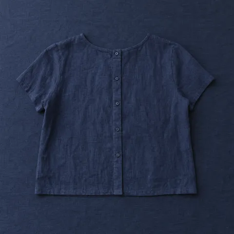 Blusa de ramio Santo Domingo en azul marino, prenda extendida sobre mantel azul