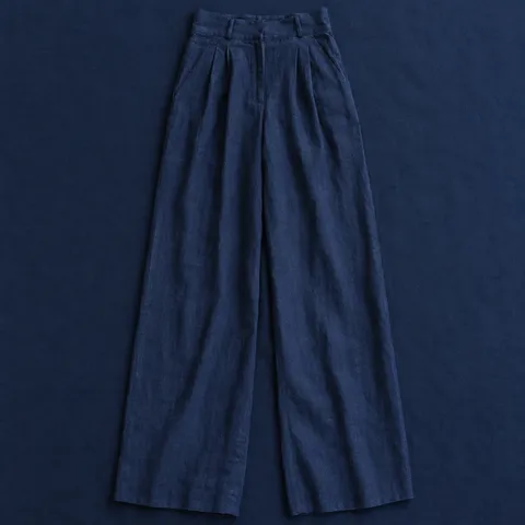 Pantalón de lino Vistabella en azul marino, prenda extendida sobre mantel azul