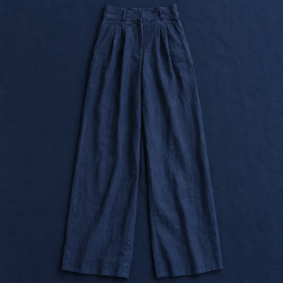 Pantalón de lino Vistabella, azul marino, extendida sobre un mantel azul oscuro