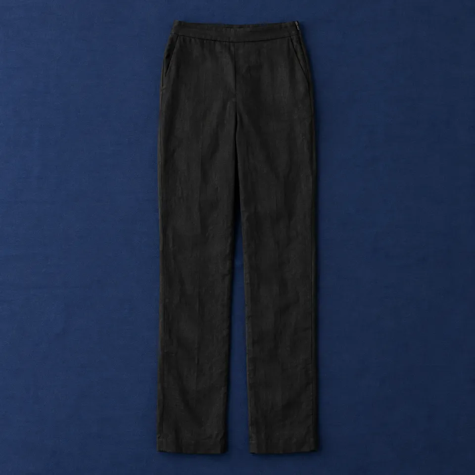 Pantalón de lino La Flota, negro, extendida sobre un mantel azul oscuro