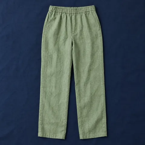 Pantalón de lino El Carmen en verde salvia, prenda extendida sobre mantel azul