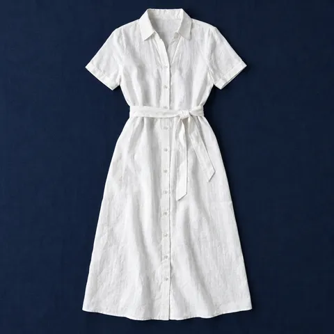 Vestido camisero Puxmarina en blanco óptico, prenda extendida sobre mantel azul