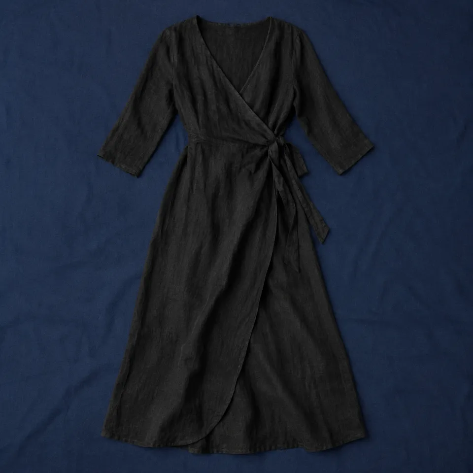 Vestido cruzado Monteagudo, negro, extendida sobre un mantel azul oscuro